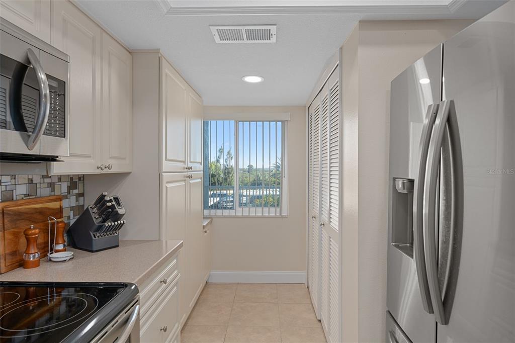 4550 Bay Boulevard, Unit 1211 Port Richey, FL 34668 - Photo 17 of 65 a kitchen with stainless steel appliances granite countertop a refrigerator and a stove top oven