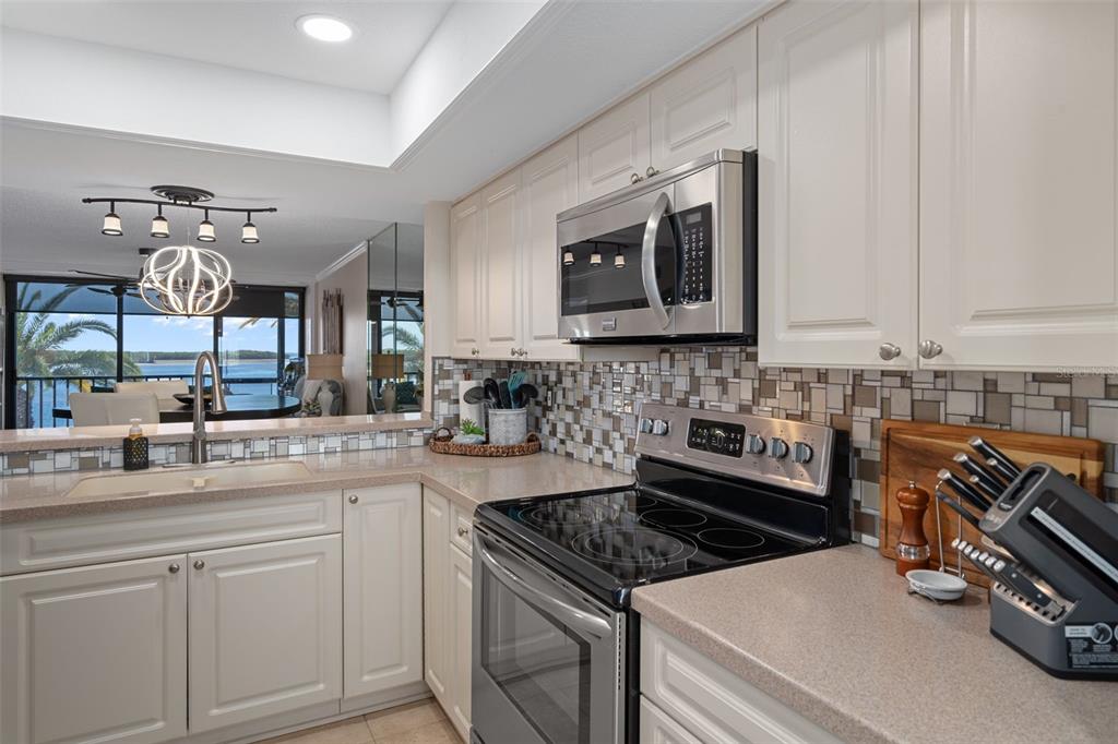 4550 Bay Boulevard, Unit 1211 Port Richey, FL 34668 - Photo 18 of 65 a kitchen with stainless steel appliances granite countertop a stove and a sink