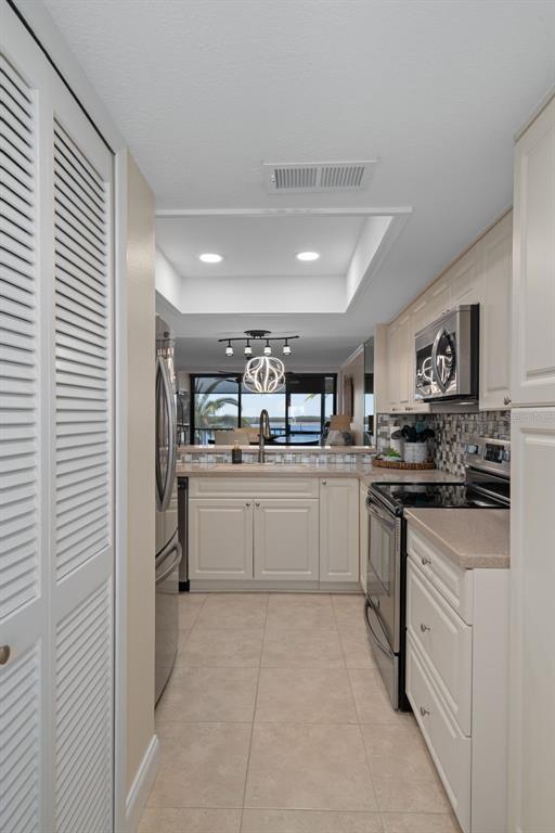 4550 Bay Boulevard, Unit 1211 Port Richey, FL 34668 - Photo 19 of 65 a kitchen with white cabinets and white appliances