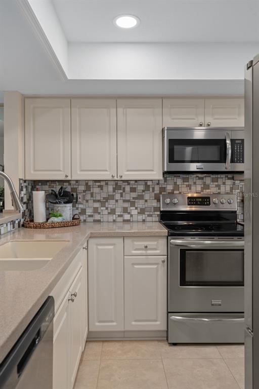 4550 Bay Boulevard, Unit 1211 Port Richey, FL 34668 - Photo 21 of 65 a kitchen with granite countertop white cabinets and stainless steel appliances