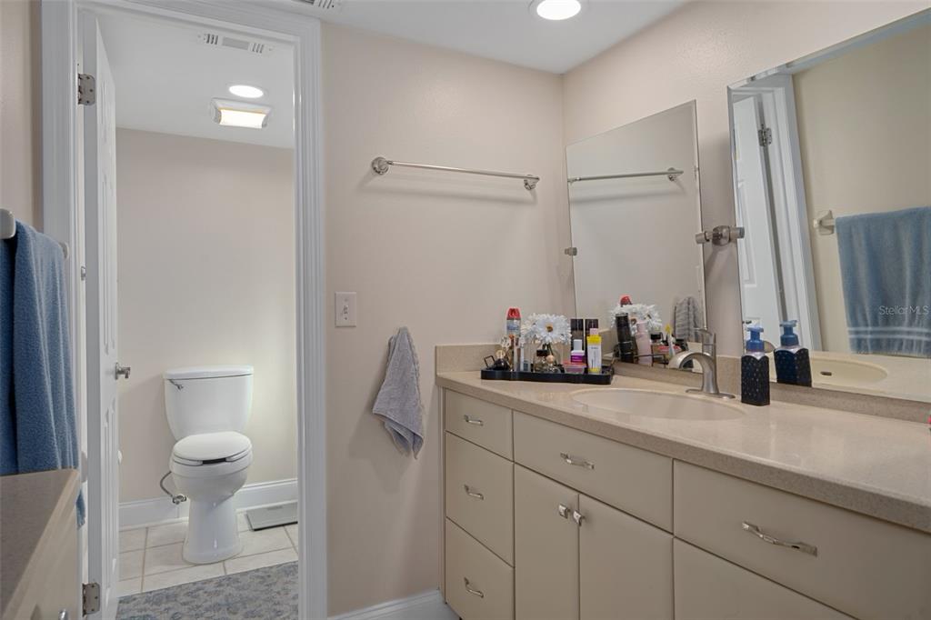4550 Bay Boulevard, Unit 1211 Port Richey, FL 34668 - Photo 27 of 65 a bathroom with a sink a toilet and a mirror