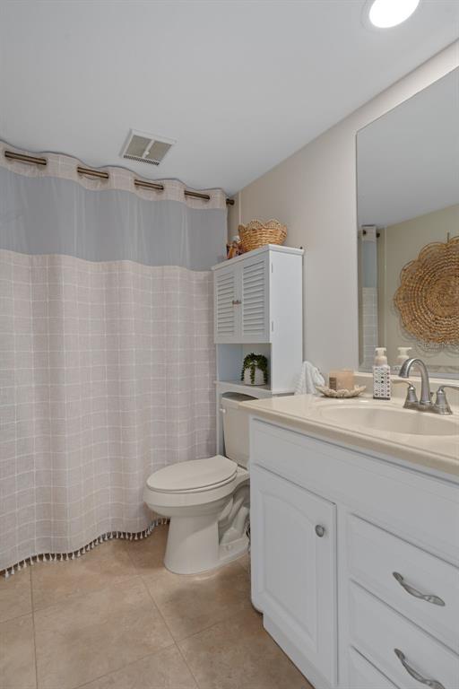 4550 Bay Boulevard, Unit 1211 Port Richey, FL 34668 - Photo 34 of 65 a bathroom with a toilet sink and mirror