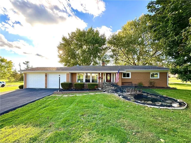 a view of a house with a yard and a garden
