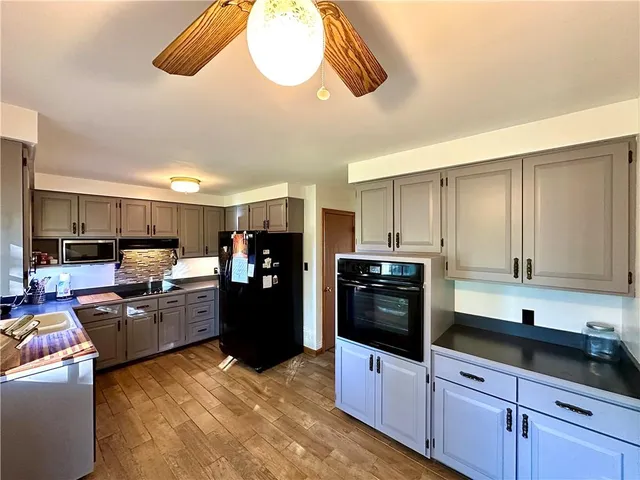 a kitchen with stainless steel appliances granite countertop a refrigerator a stove a sink and a microwave