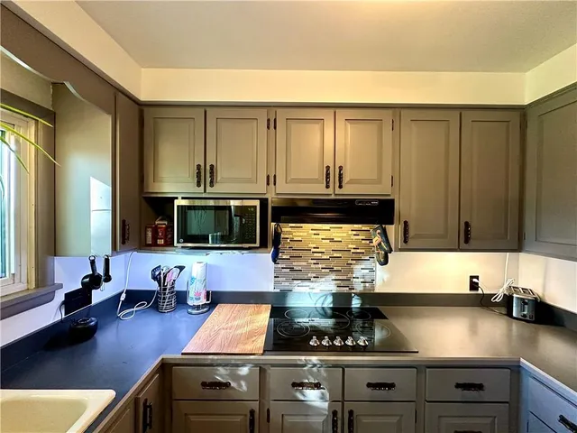 a kitchen with stainless steel appliances granite countertop a stove and a microwave