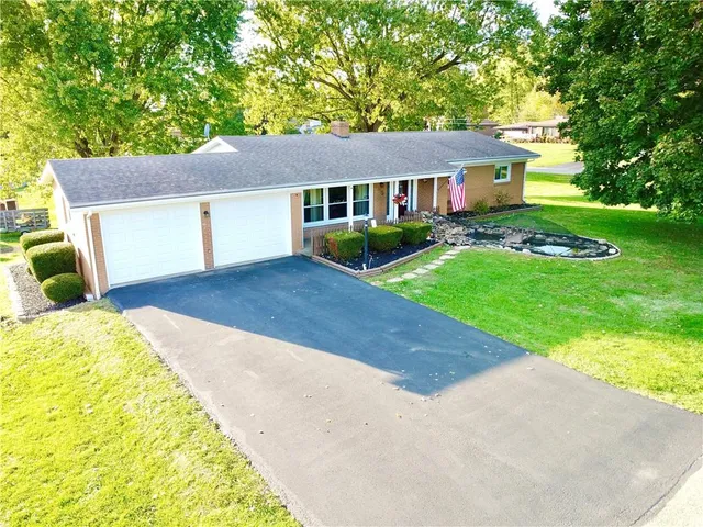 a front view of a house with a garden and yard