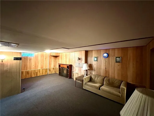 a view of an empty room with wooden floor and a bathroom