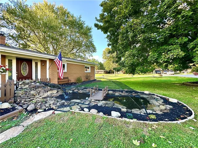 a view of a house with backyard and sitting area