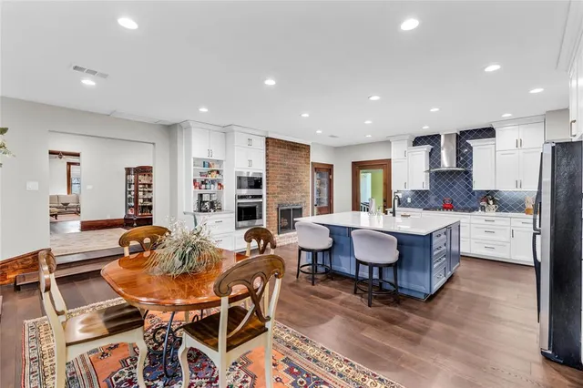 a dining room with furniture a rug and kitchen view