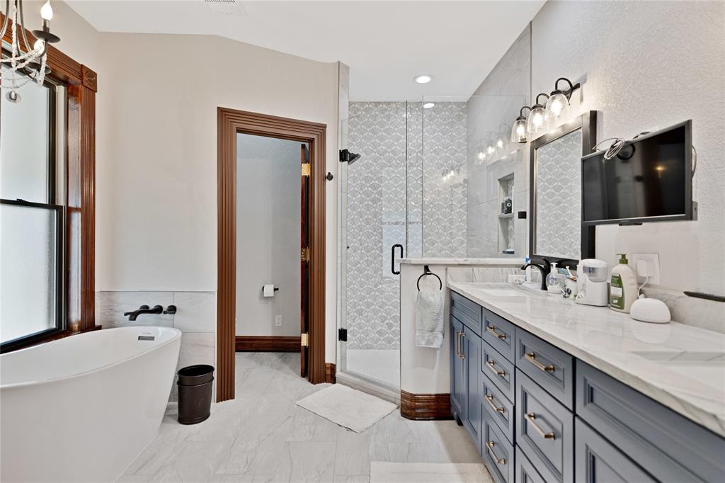 304 North Church Street Pilot Point, TX 76258 - Photo 34 of 40 a spacious bathroom with a granite countertop sink mirror and bathtub
