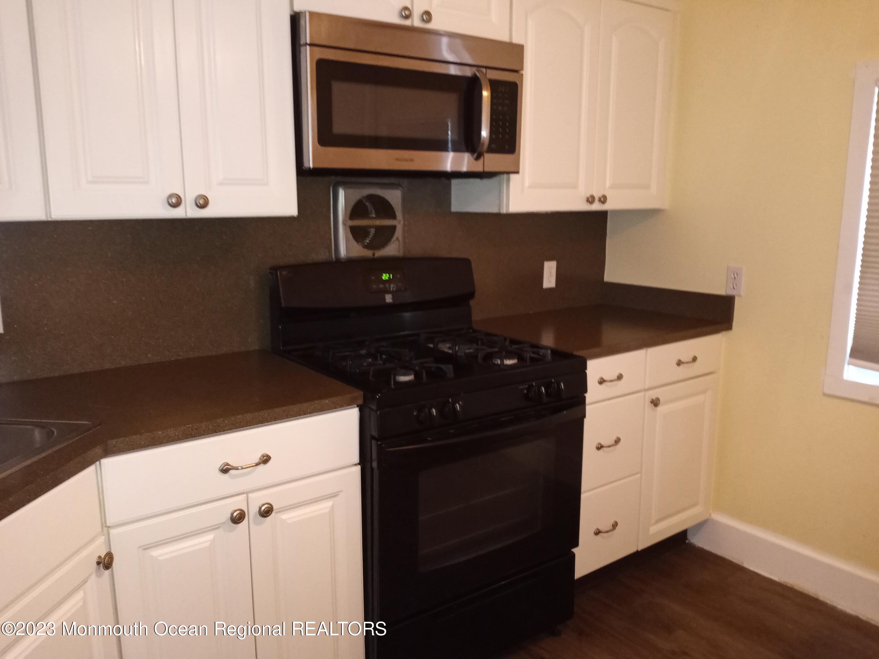 274 Lane C Hazlet, NJ 07730 - Photo 4 of 19 a kitchen with stainless steel appliances a stove a microwave and cabinets