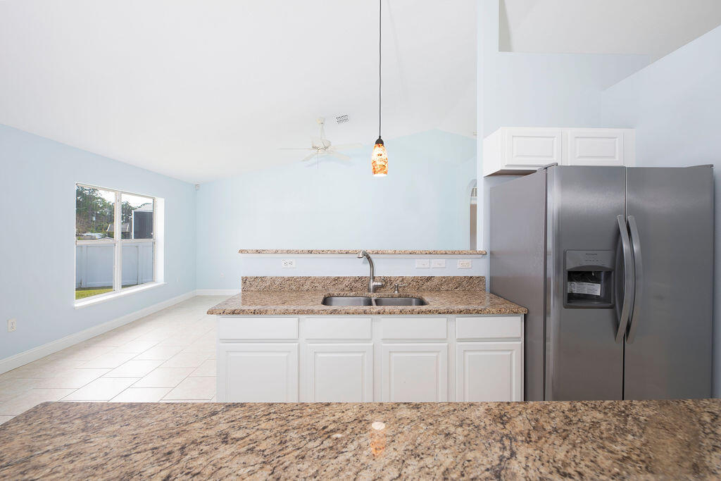 1815 Dragon Road Southeast Palm Bay, FL 32909 - Photo 16 of 41 a kitchen with stainless steel appliances granite countertop a sink and a refrigerator