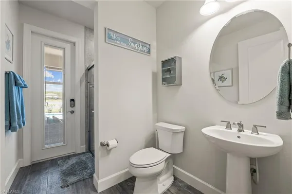 a bathroom with a toilet sink and mirror