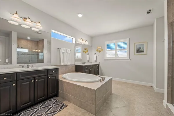 a bathroom with a sink a large mirror and a bathtub