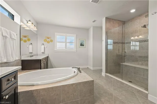 a spacious bathroom with a granite countertop tub sink shower and mirror