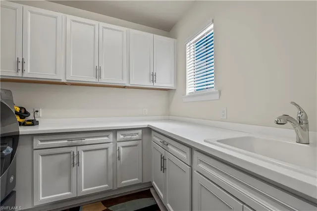 a kitchen with white cabinets and a sink