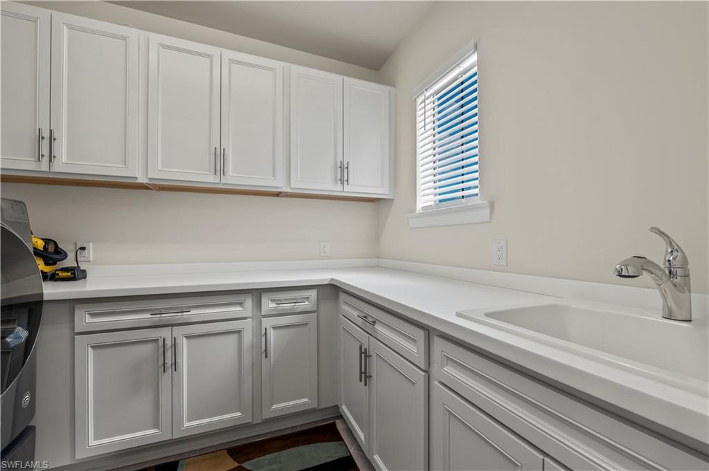 19157 Elston Way Estero, FL 33928 - Photo 27 of 50 a kitchen with white cabinets and a sink