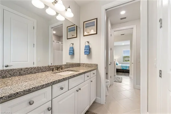 a en suite bathroom with a granite countertop sink and a mirror