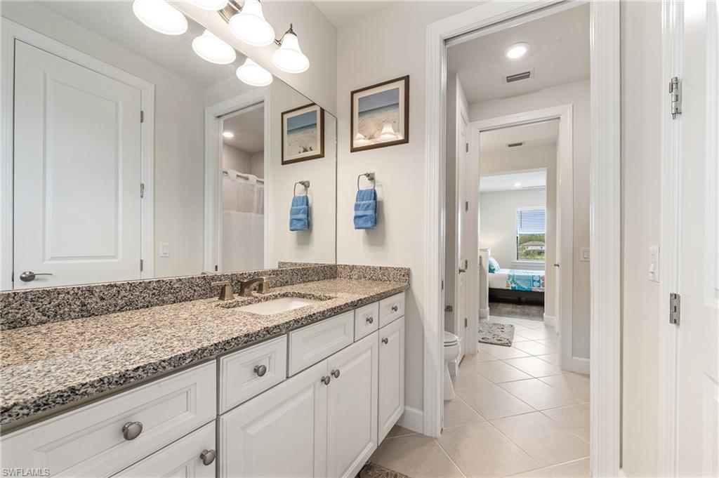 19157 Elston Way Estero, FL 33928 - Photo 29 of 50 a en suite bathroom with a granite countertop sink and a mirror