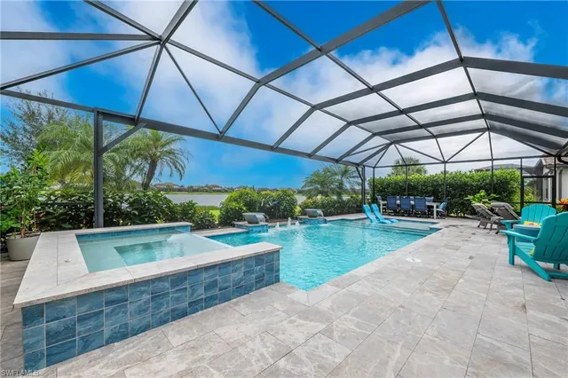 a view of a backyard with lawn chairs under an umbrella