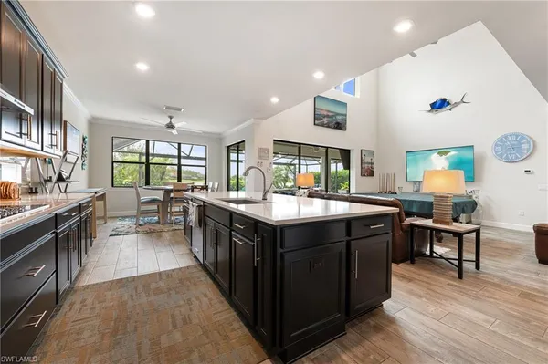 a kitchen with a stove kitchen island and couches with wooden floor