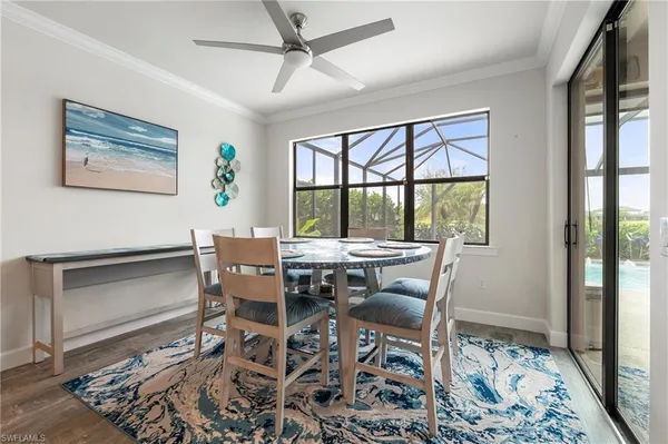 a dining room with wooden floor and a rug