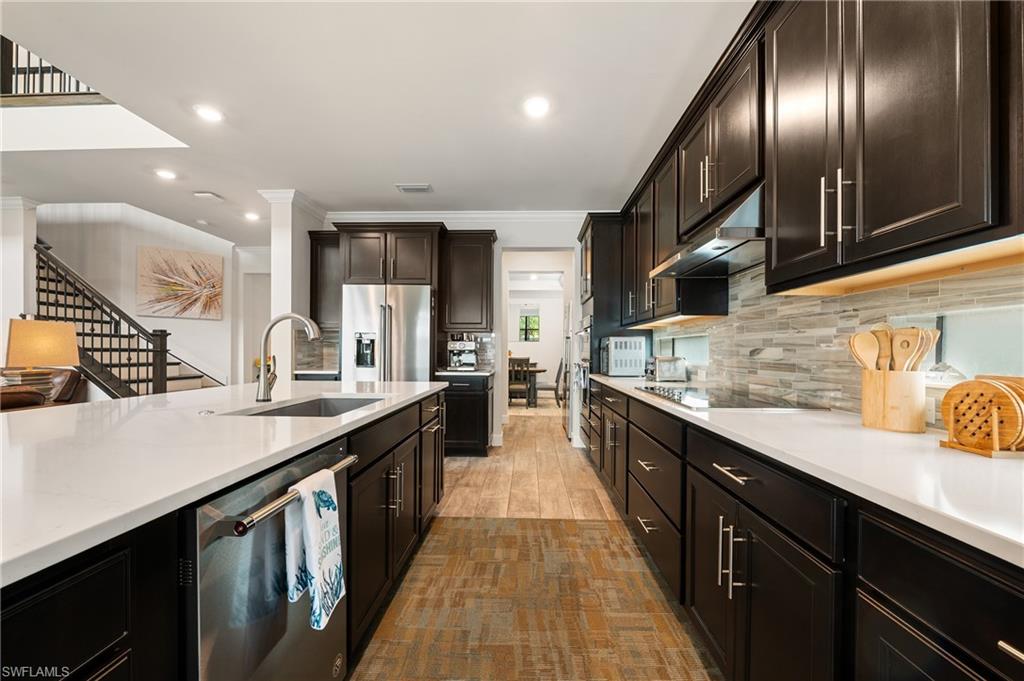 19157 Elston Way Estero, FL 33928 - Photo 6 of 50 a kitchen with stainless steel appliances sink a stove and cabinets