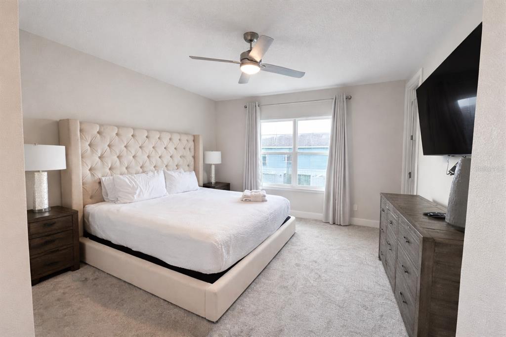 7909 Draw Street Reunion, FL 34747 - Photo 11 of 12 a bedroom with a bed and a flat tv screen on dresser