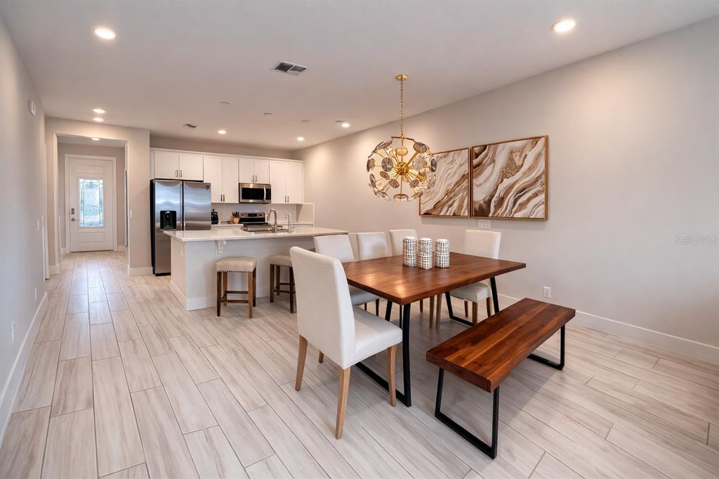 7909 Draw Street Reunion, FL 34747 - Photo 2 of 12 a view of a dining room with furniture wooden floor and a rug