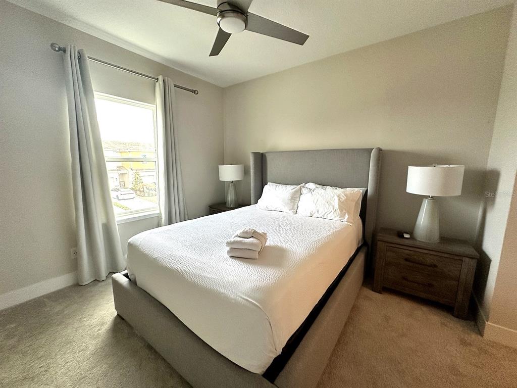 7909 Draw Street Reunion, FL 34747 - Photo 4 of 12 a large bed sitting in a bedroom next to a window