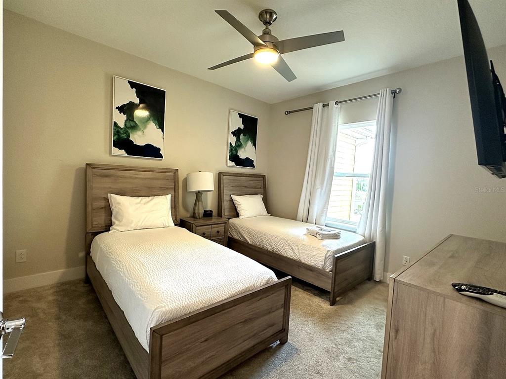 7909 Draw Street Reunion, FL 34747 - Photo 7 of 12 a bedroom with two beds and a chandelier