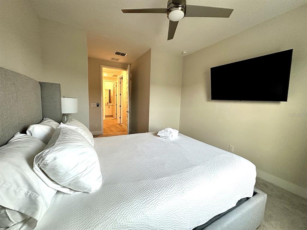 7909 Draw Street Reunion, FL 34747 - Photo 9 of 12 a bedroom with a bed and a flat screen tv