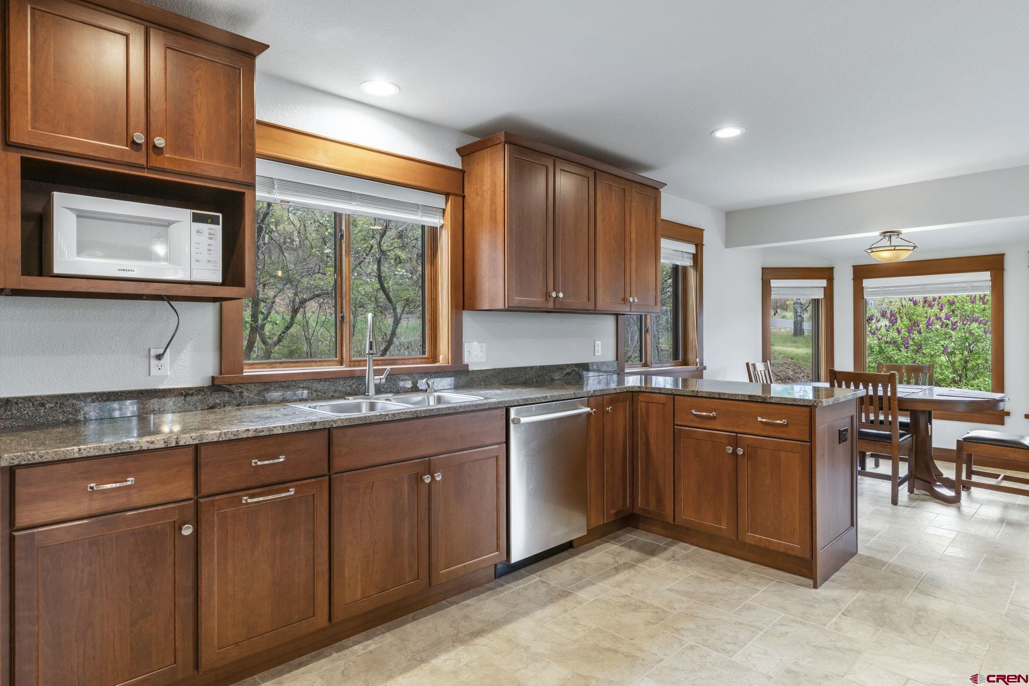 24 Songbird Lane Durango, CO 81301 - Photo 19 of 45 a kitchen with stainless steel appliances granite countertop wooden cabinets a sink and a large window