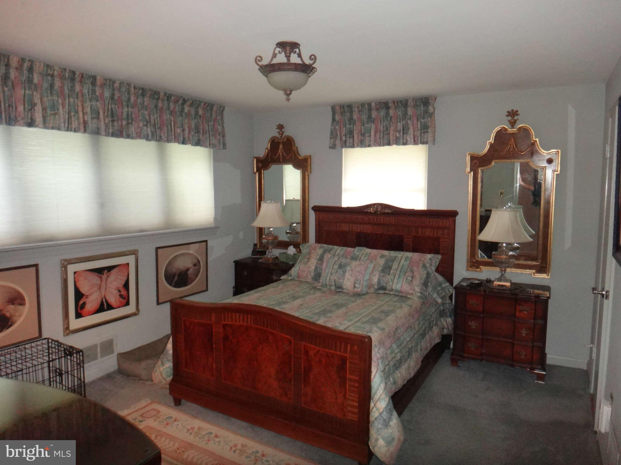 10128 Riggs Road Adelphi, MD 20783 - Photo 18 of 30 a spacious bedroom with a bed and a window