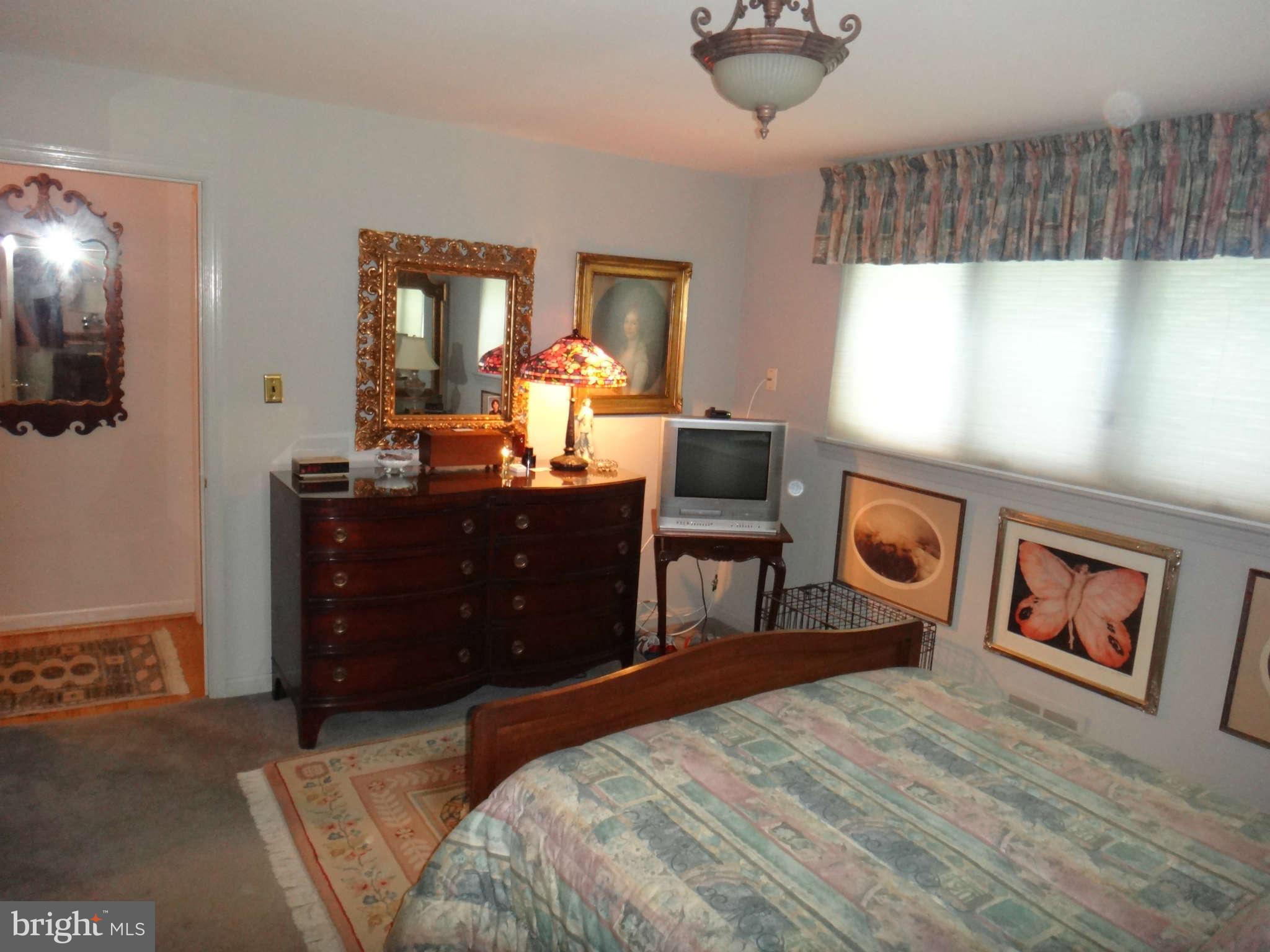 10128 Riggs Road Adelphi, MD 20783 - Photo 19 of 30 a bedroom with a bed and a dresser in it