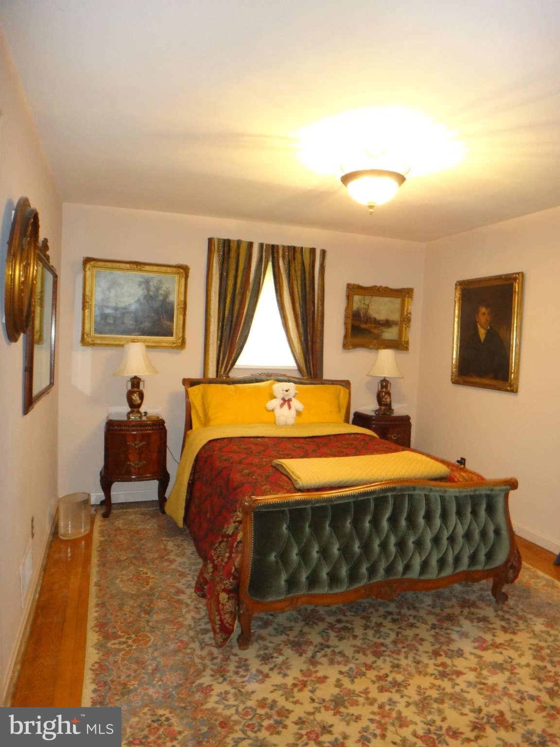 10128 Riggs Road Adelphi, MD 20783 - Photo 24 of 30 a bedroom with a bed and wooden floor