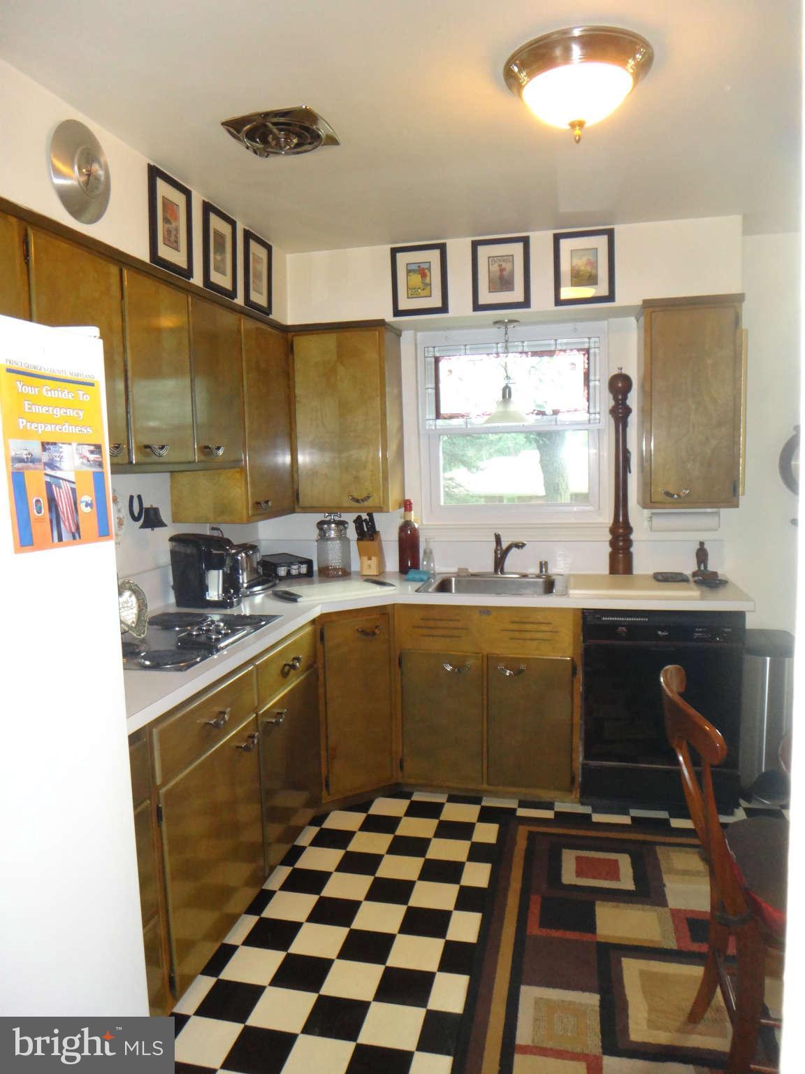 10128 Riggs Road Adelphi, MD 20783 - Photo 10 of 30 a kitchen with a sink a stove cabinets and a window