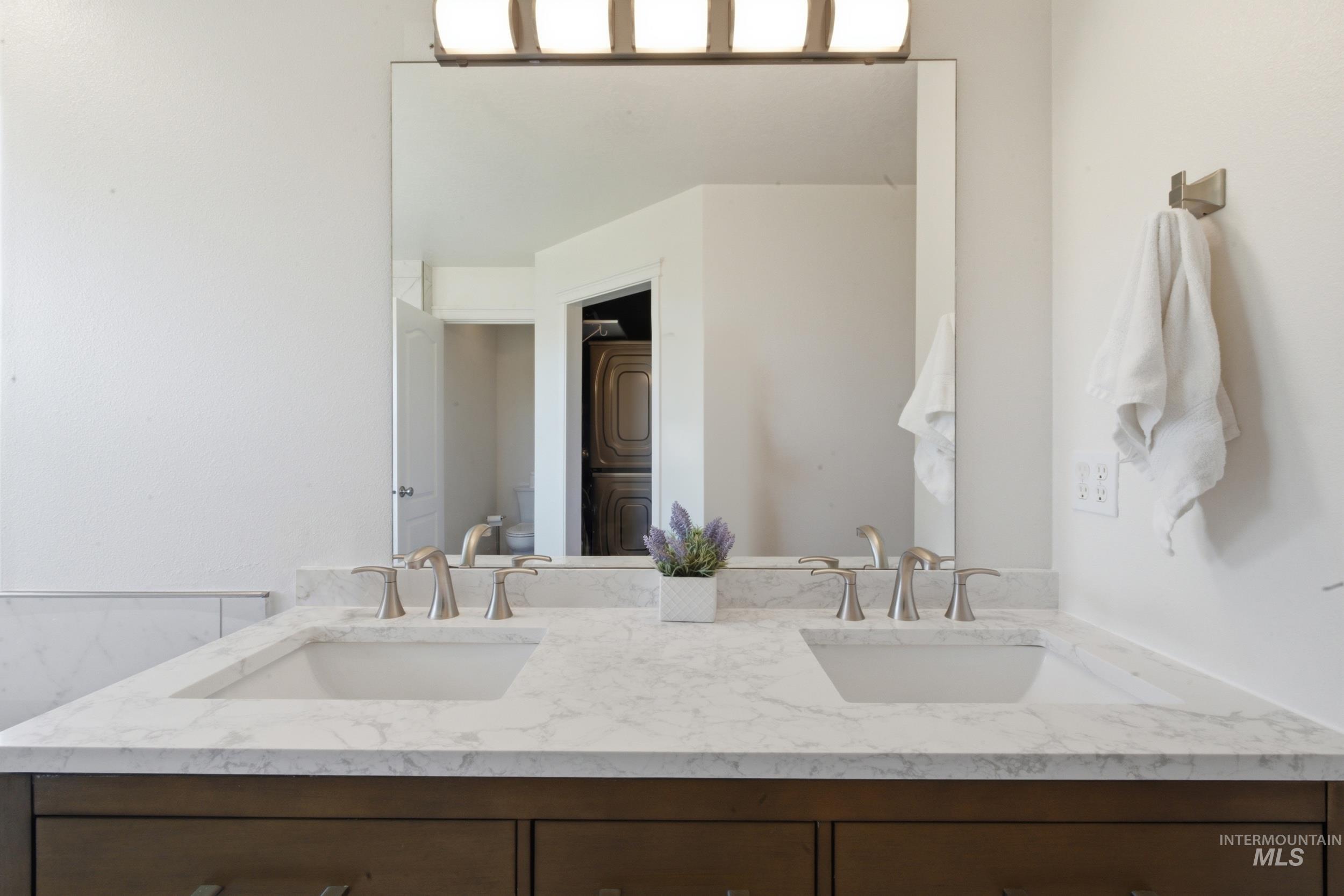 7781 Redmon Road Caldwell, ID 83607 - Photo 47 of 50 Bathroom vanity with integrated sink, gold-finish faucet, and white framed mirror