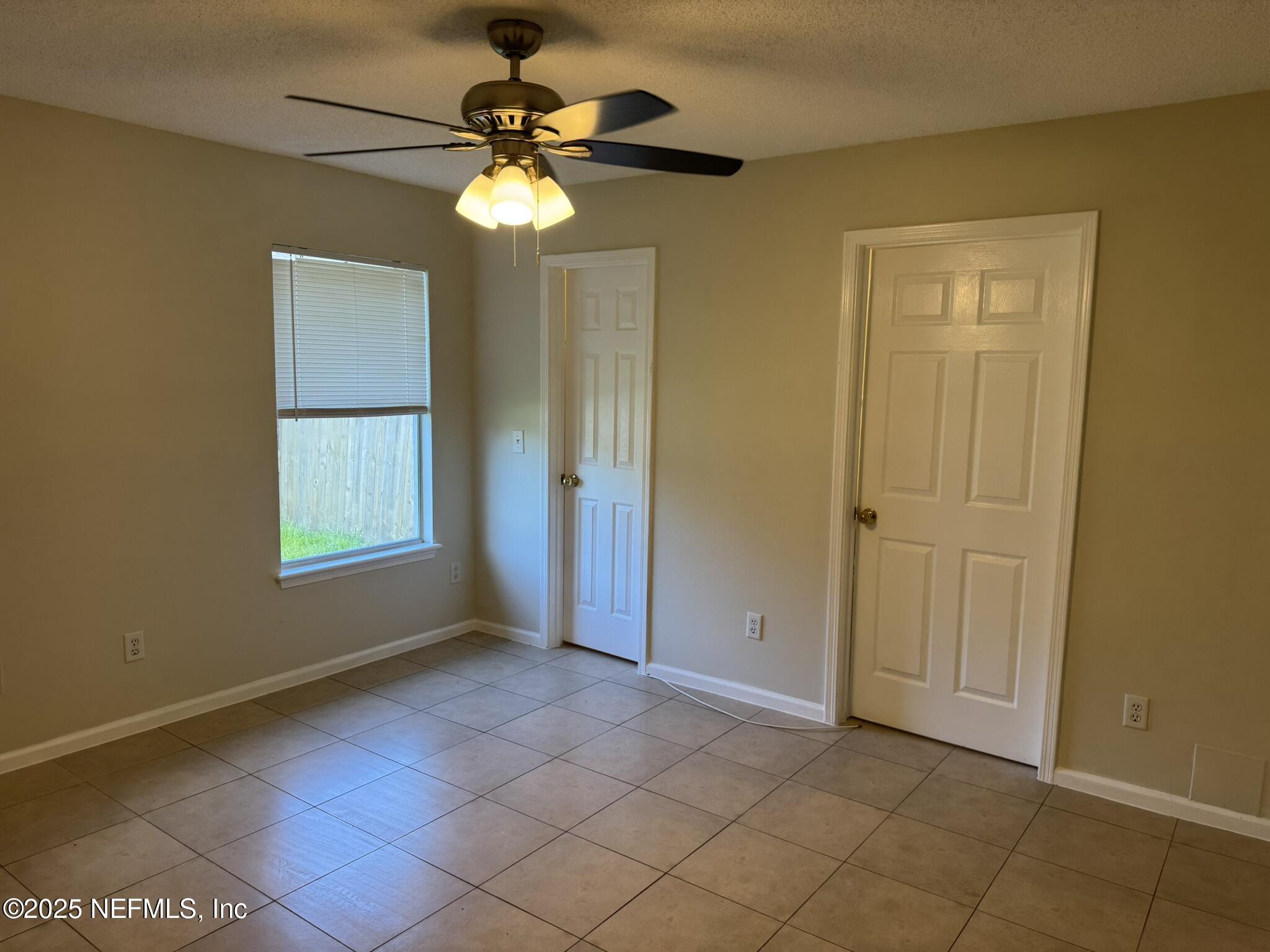 84042 St James Court Yulee, FL 32097 - Photo 14 of 44 a view of an empty room with window and chandelier fan