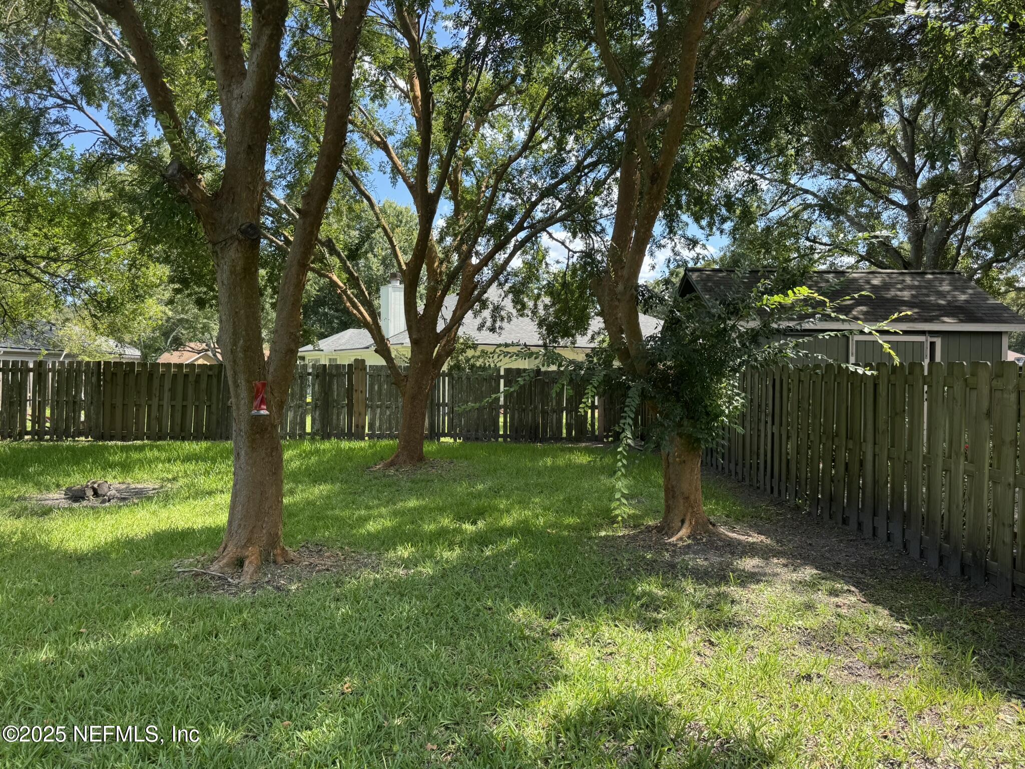 84042 St James Court Yulee, FL 32097 - Photo 41 of 44 a backyard of a house with plants and large tree