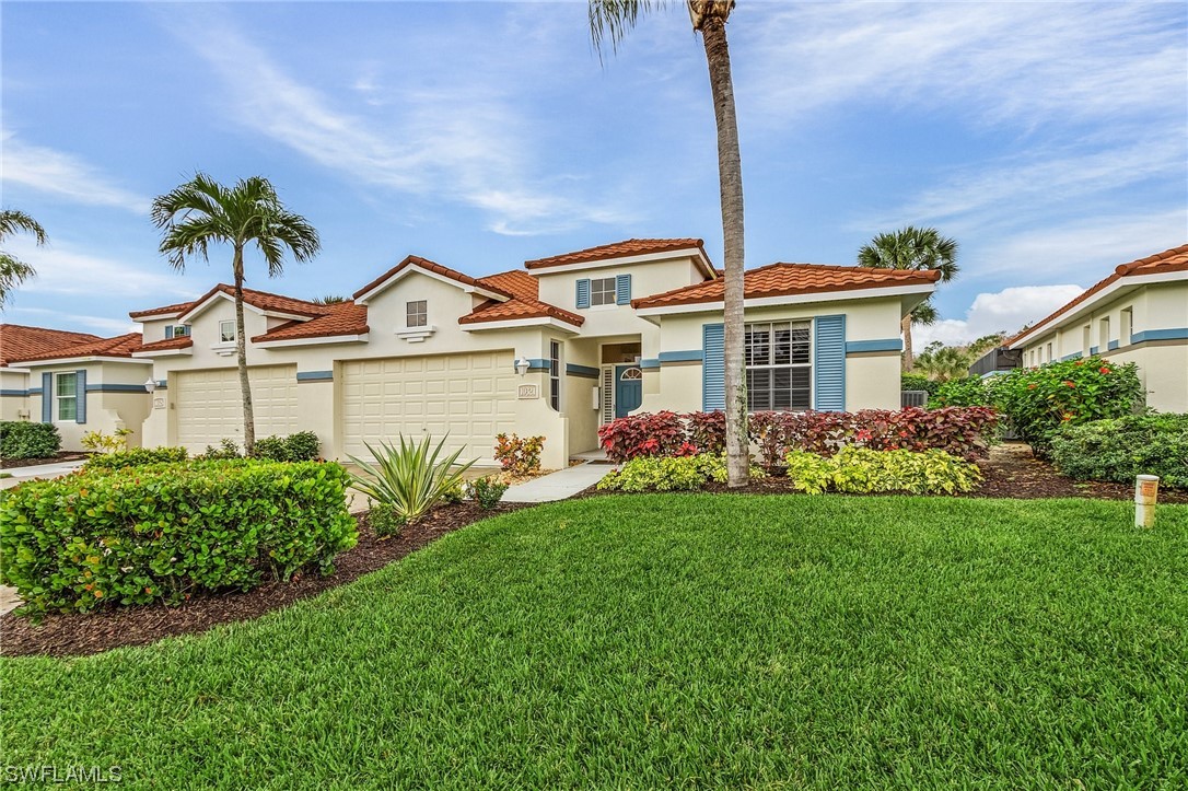 10321 Cape Roman Road, Unit 102 Estero, FL 34135 - Photo 1 of 33 a front view of a house with a garden