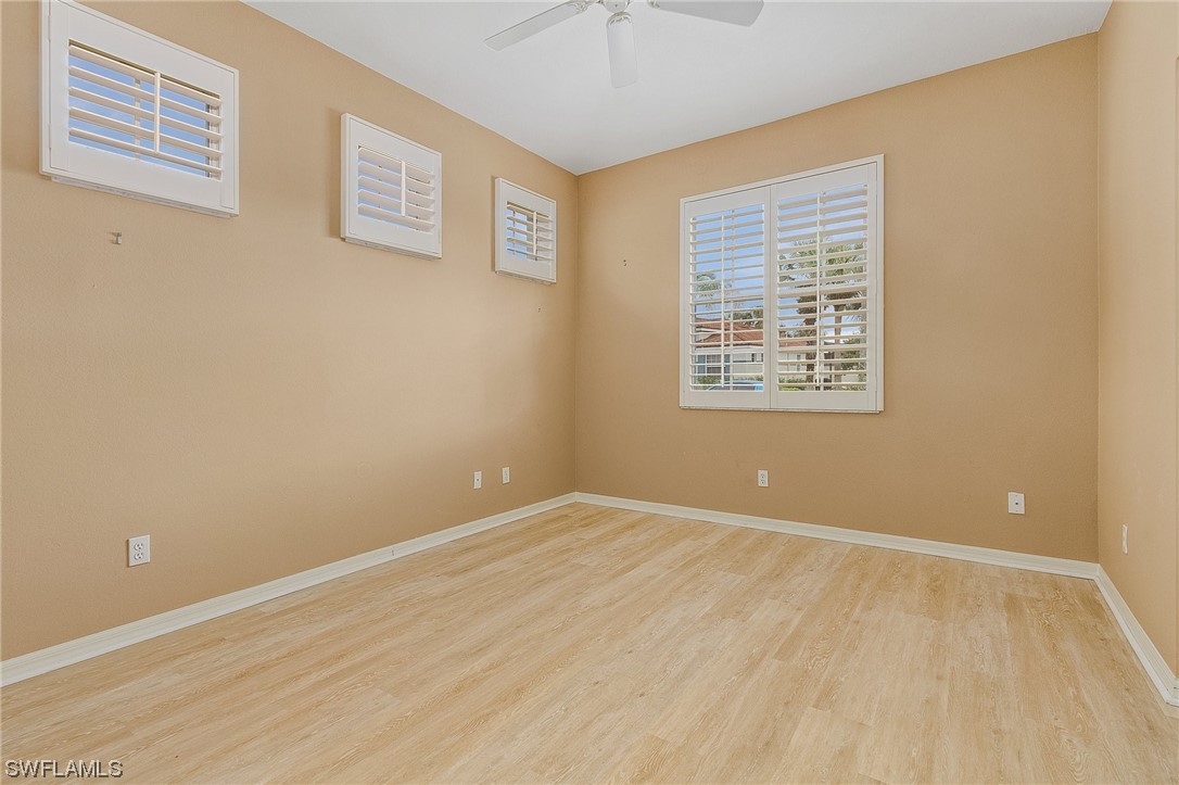 10321 Cape Roman Road, Unit 102 Estero, FL 34135 - Photo 13 of 33 a view of an empty room with wooden floor and a window