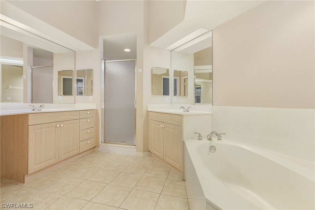 10321 Cape Roman Road, Unit 102 Estero, FL 34135 - Photo 18 of 33 a spacious bathroom with a bathtub sink and mirror