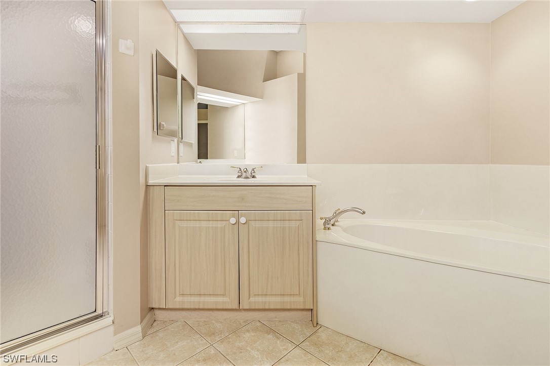 10321 Cape Roman Road, Unit 102 Estero, FL 34135 - Photo 19 of 33 a bathroom with a sink a toilet and a mirror