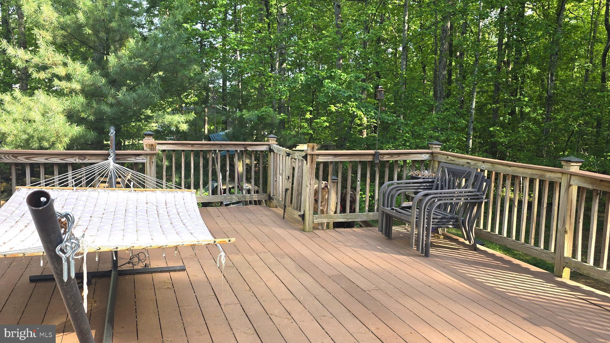 17155 Hudson Mill Road Culpeper, VA 22701 - Photo 28 of 39 a deck with table and chairs a barbeque with wooden floor and fence