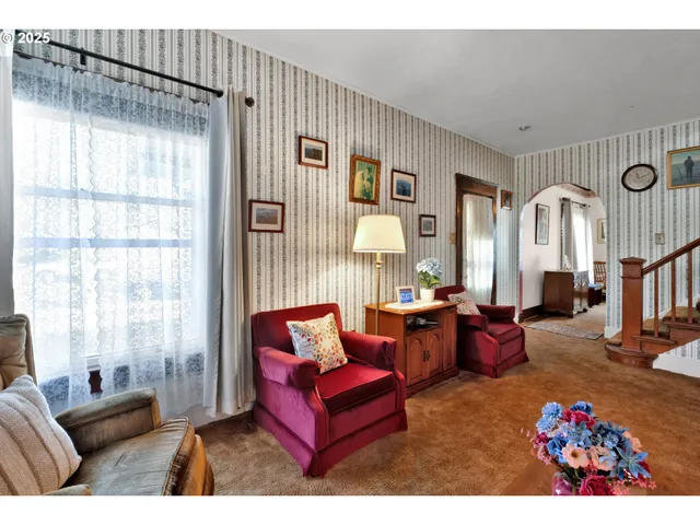 a living room with furniture a flat screen tv and a window