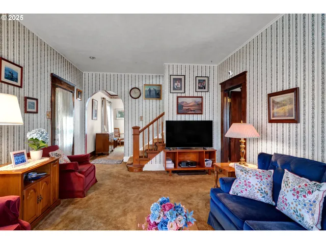 a living room with furniture a window and a flat screen tv