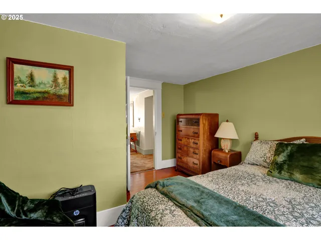 a view of a bedroom with wooden floor and a balcony
