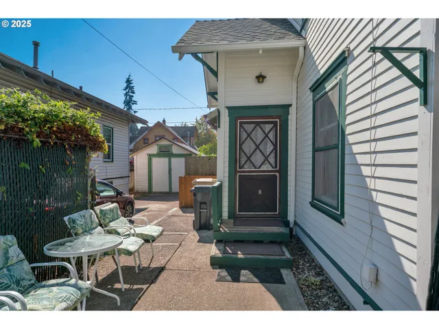 a balcony with table and chairs and potted plants