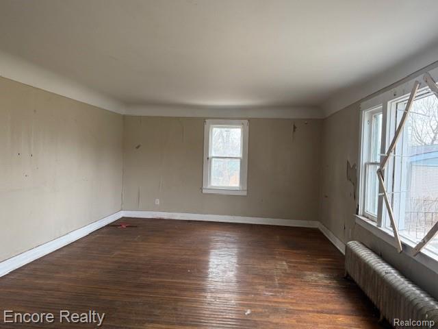 19300 Berg Road Detroit, MI 48219 - Photo 7 of 28 Spare room featuring radiator heating unit and dark wood finished floors